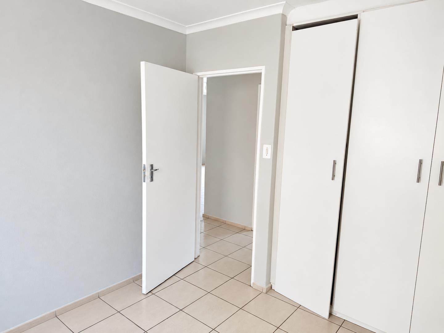 769852_Minimalist_Bedroom_with_Open_Door_and_Wardrobe.png